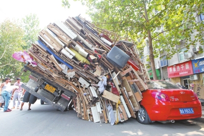 紅色小轎車被砸，卡在路邊動彈不得。