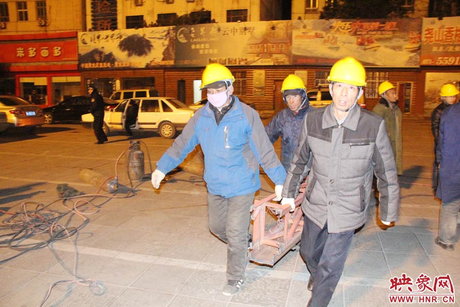 23點56分，第一塊兒廣告牌已經分割完畢，地面上的20多名工人將拆除下來的鋼件撞車運走。