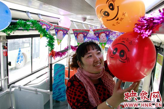 鄭州快速公交B3區(qū)間線車長李鵬云在車廂里懸掛氣球，布置圣誕車廂，營造歡樂圣誕氛圍