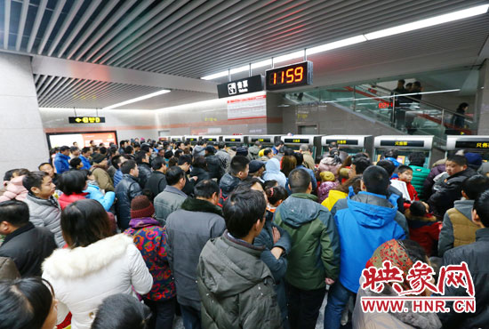 地鐵開通首日，上午十一點五十九分，紫荊山地鐵站售票機前擠滿了買票的市民。