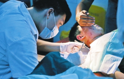 孩子身上有7道傷痕，其中兩道需要縫合，其他的均為擦傷，醫(yī)生正對他施治。