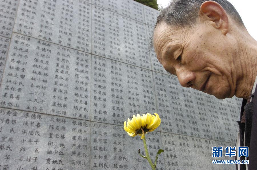 2006年4月5日，74歲的南京大屠殺幸存者佘子清手捧鮮花，祭奠被日軍殺害的母親。