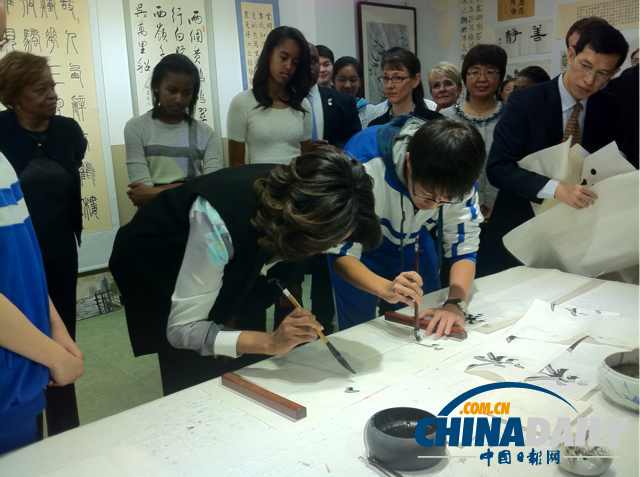 　北京時(shí)間3月21日，美國第一夫人米歇爾參觀北師大二附中時(shí)，與學(xué)生一起練習(xí)書法。