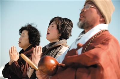 23日，一名僧侶引領(lǐng)人們?yōu)樗勒咂矶\。