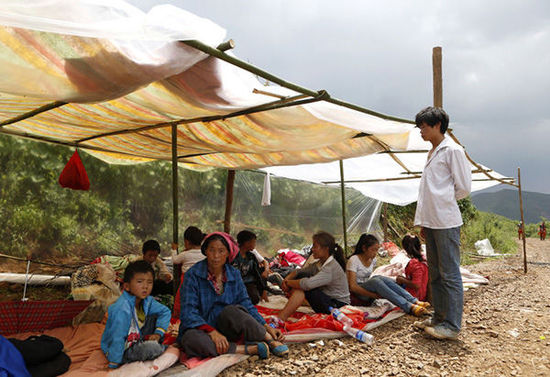 暴雨馬上來(lái)臨，村民們?cè)诤?jiǎn)易帳篷下躲雨。澎湃新聞 程藝輝 圖