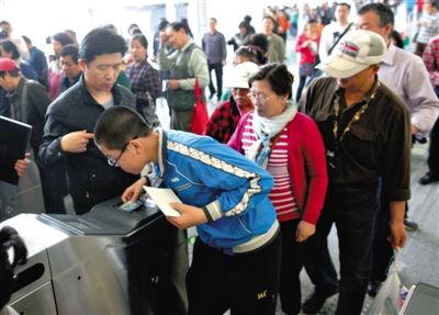 去年5月5日，14號(hào)線園博園站，乘客刷卡出地鐵。北京公交地鐵將實(shí)行計(jì)程票制，多乘坐多付費(fèi)。