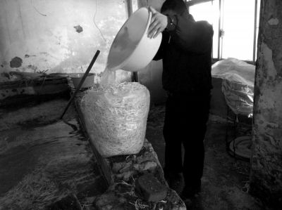 作坊內(nèi)工人用攪拌有漂白粉的藥水給豆芽增白。