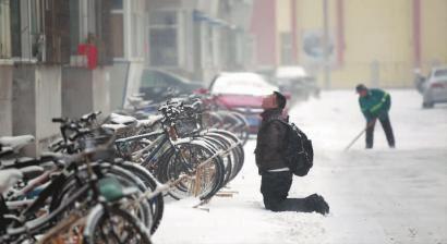 小伙子跪在樓前，一直抬頭看著樓上。 孫立國/攝