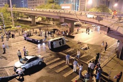 路虎沖下國貿(mào)橋砸中一輛起亞轎車，橋上厚達(dá)幾十厘米的水泥護(hù)欄被撞斷，碎石四處散落，數(shù)十群眾在現(xiàn)場圍觀。