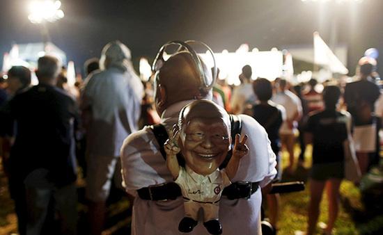 9月4日，新加坡，執(zhí)政黨的一場(chǎng)集會(huì)上，一名支持者背著一個(gè)李光耀的人偶。