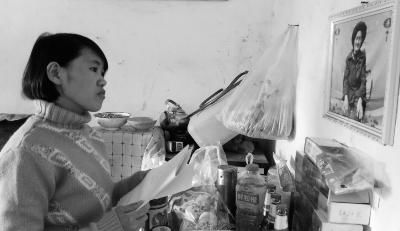 錢仁鳳站在母親遺像前。未能見母親最后一面是她的一大遺憾。