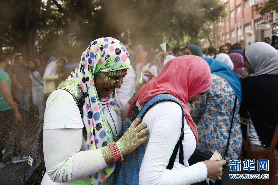 10月16日，在埃及首都開羅，兩名女青年在“彩色跑”活動中躲避人們拋撒的彩色粉末。