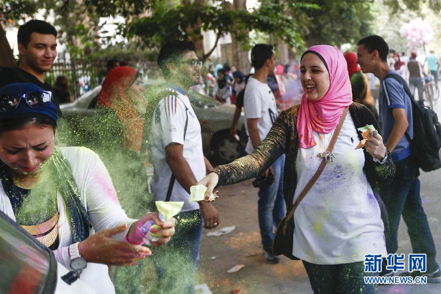 10月16日，在埃及首都開羅，一名女青年在“彩色跑”活動中拋撒彩色粉末。