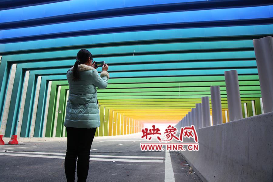 一女孩拿出手機(jī)拍照。