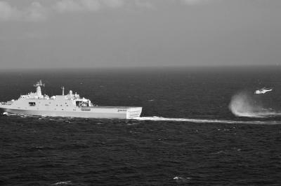 11日，抵達馬航飛機失聯(lián)海區(qū)的海軍井岡山艦與艦載直升機協(xié)同展開立體搜救行動。新華社發(fā)