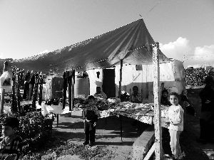 黎巴嫩一敘利亞難民營(yíng)，難民支起攤鋪賣(mài)衣服掙錢(qián)。