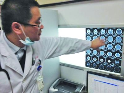 醫(yī)生在查看男孩的腦部CT片。薛馬義 攝