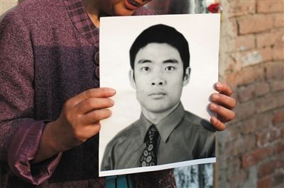 5月19日，朝陽北路，母親捧著張東文的遺像。新京報(bào)記者 侯少卿 攝