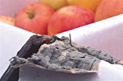 8月29日，新發(fā)地市場，一箱用“加重紙箱”包裝的蘋果正待售，紙箱夾層內(nèi)灰黑色的增重填充物清晰可見