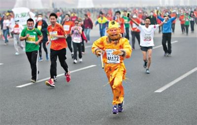 長(zhǎng)安街，一名打扮成孫悟空的參賽者在北馬隊(duì)伍里飛奔。 本版攝影/新京報(bào)記者 吳江 李飛 王嘉寧 吳江