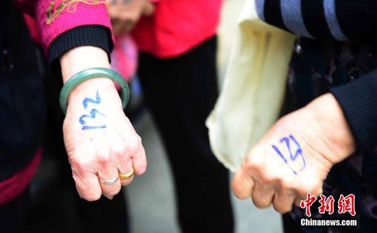 圖為10月28日，在江西九江市一家羊絨皮草服裝服飾博覽會現(xiàn)場，老人們正在頂著寒風(fēng)排隊(duì)等待領(lǐng)取10元代金劵。