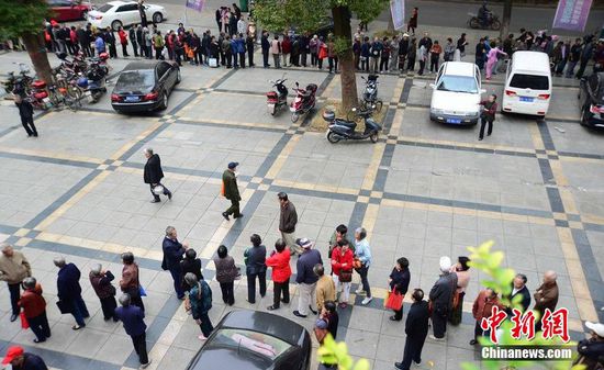 圖為10月28日，在江西九江市一家羊絨皮草服裝服飾博覽會現(xiàn)場，老人們正在頂著寒風(fēng)排隊(duì)等待領(lǐng)取10元代金劵。