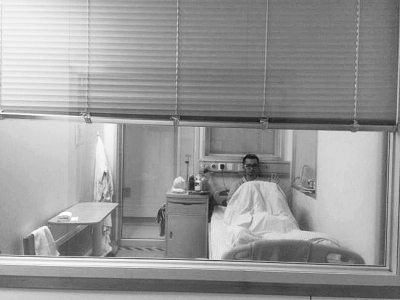 楊杰在醫(yī)院隔離病房中，沖記者揮了揮手。