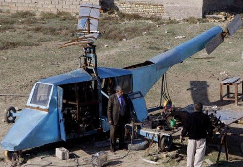 哈蒂姆·卡迪姆·薩爾曼正與工人交談，背后就是他正在制造的直升機(jī)