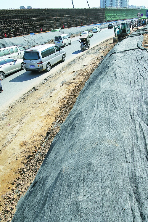 豐樂路與北三環(huán)交叉口，修路的土被歸置得整整齊齊，并用黑網(wǎng)覆蓋，既保暢通又避免了揚塵。
