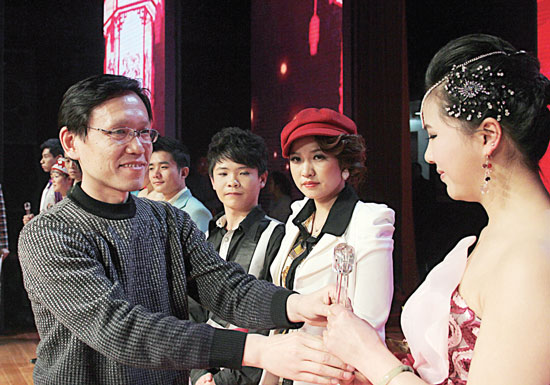 2013年2月1日，《對(duì)9當(dāng)歌》總決賽在鄭州開(kāi)唱。圖為東方今報(bào)副社長(zhǎng)胡楊為選手頒獎(jiǎng)