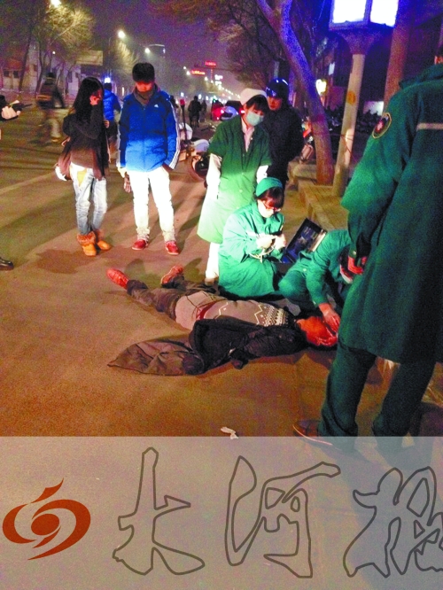 醉漢躺在地上，醫(yī)護(hù)人員對其進(jìn)行檢查。